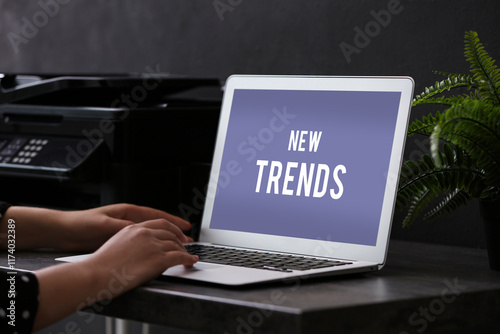 New trends. Woman using laptop at table in office, closeup