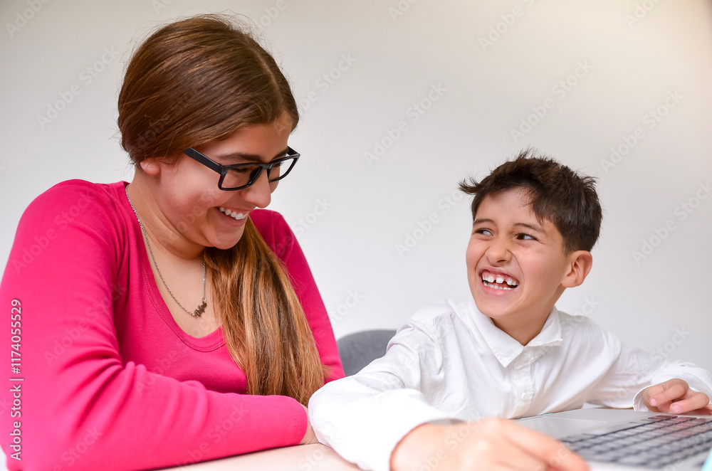 Happy tutor and student laughing while studying on laptop together Happy tutor and student laughing while studying on laptop together