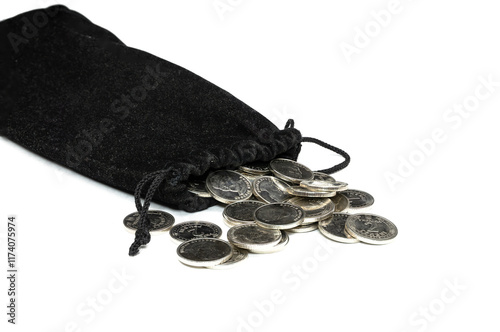 Coins spill out of a black pouch onto a white surface in a close-up view photo