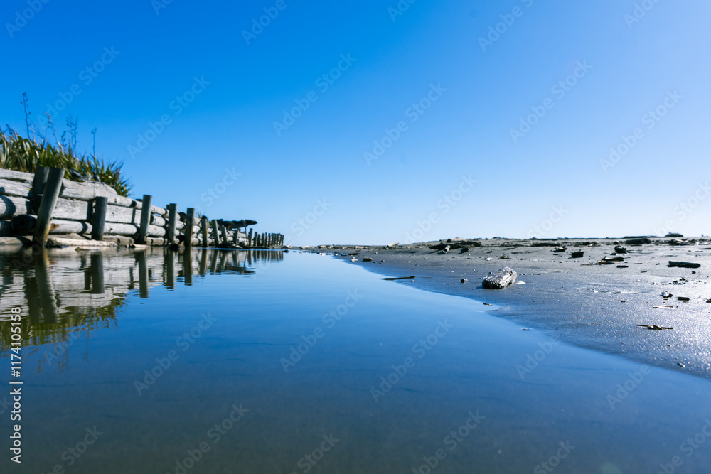 Sky reflected in the water at Raumati Beach, New Zealand Sky reflected in the water at Raumati Beach, New Zealand
