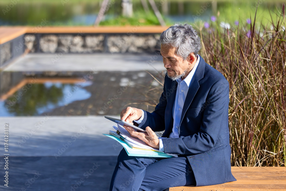 Obraz premium Portrait of confidence senior asian CEO businessman is holding document and digital tablet at his modern office for market leader, manager, executive corporate and millionaire concept