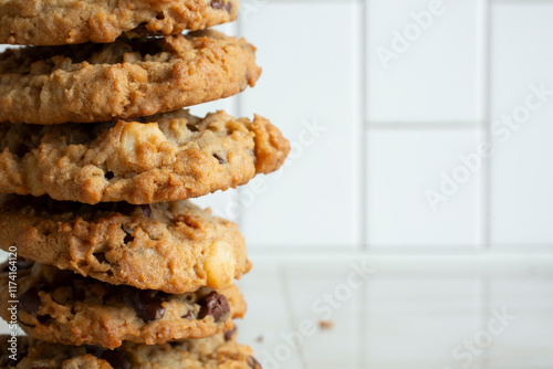 A view of a stack of oatmeal chocolate chip cookies, on the left side of the frame. photo