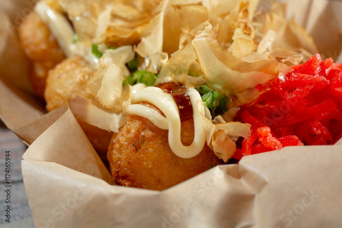 A closeup view of a carton of takoyaki.  photo