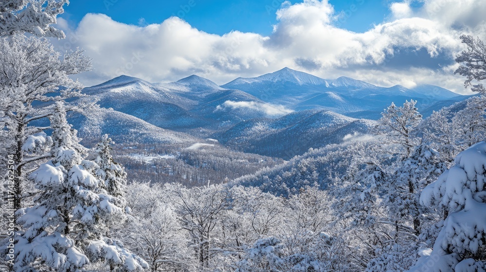Majestic snow-covered mountain range under a blue sky with fluffy clouds showcasing winter's natural beauty and serene landscape.