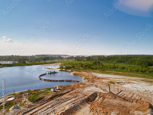 Suction tube dredger in sand mining quarry on sunny day