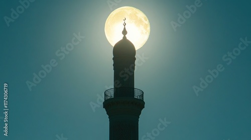 Silhouette of a mosque minaret against a large full moon. Ideal for Ramadan or Islamic-themed projects and backgrounds. photo