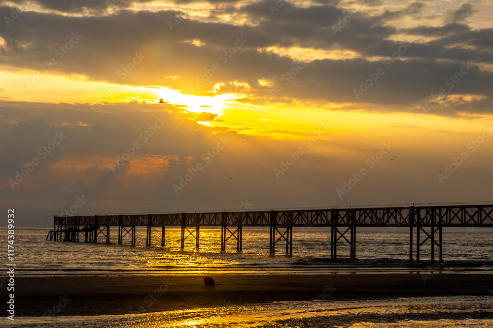 Obraz premium sunrise on beach with a trestle at Cervia Italy