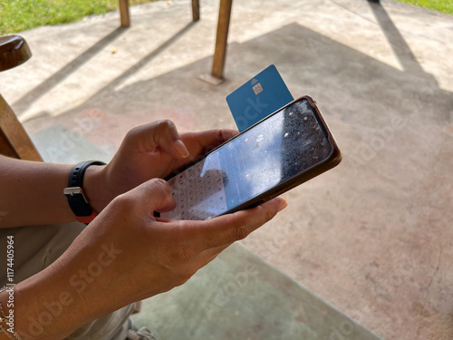 female hands holding a mobile phone and a credit card, she is shopping online from Latin America