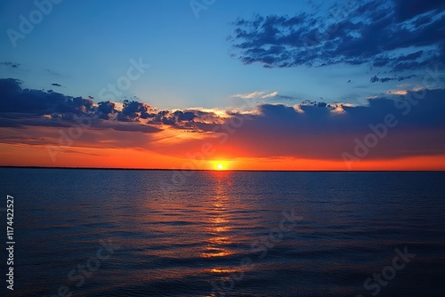 Dramatic sunset featuring an American flag gently waving over a serene horizon.