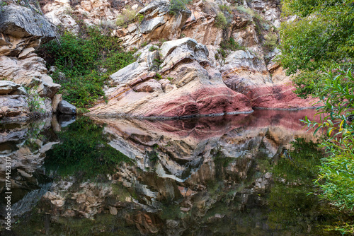 Rock formations reflect on still water