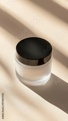 Top-down view of a frosted glass cream jar with black lid, isolated on a clean white background photo