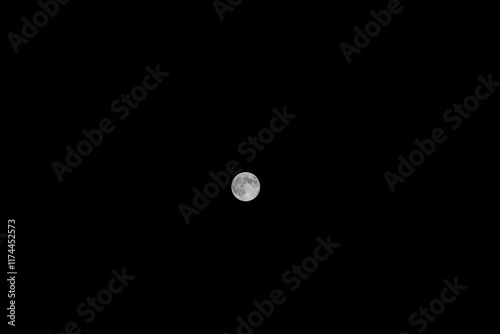 Luna llena en el centro de un fondo negro, destacando sus cráteres y detalles con claridad. Una imagen minimalista que resalta la belleza y misterio del espacio nocturno. photo