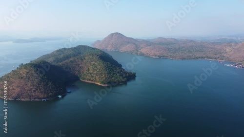 Aerial landscape view of Sri Nakarin Dam is a water storage dam for electricity generation and agriculture in the middle of a valley in Kanchanaburi, Thailand.