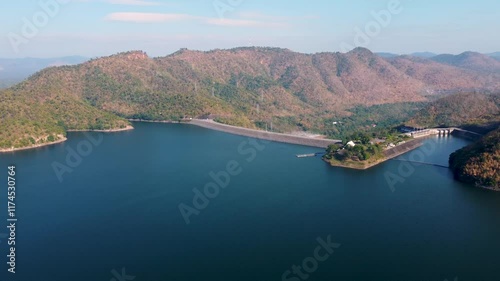 Aerial landscape view of Sri Nakarin Dam is a water storage dam for electricity generation and agriculture in the middle of a valley in Kanchanaburi, Thailand.