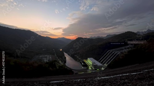 Aerial landscape view of Sri Nakarin Dam is a water storage dam for electricity generation and agriculture in the middle of a valley in Kanchanaburi, Thailand.