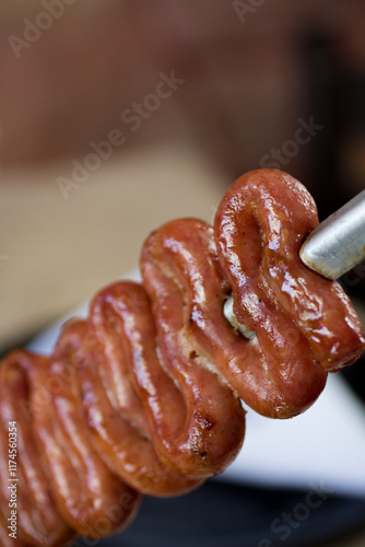 Close-up of a Brazilian-style white sausage skewer with intricate details, smoky and golden crust. photo