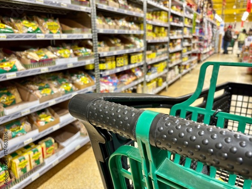 Closeup of black and green shopping cart in spice aisle of supermarket