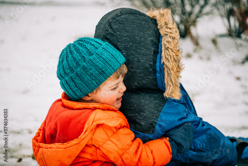 Winter cuddles bring laughter and warmth amidst the snow photo