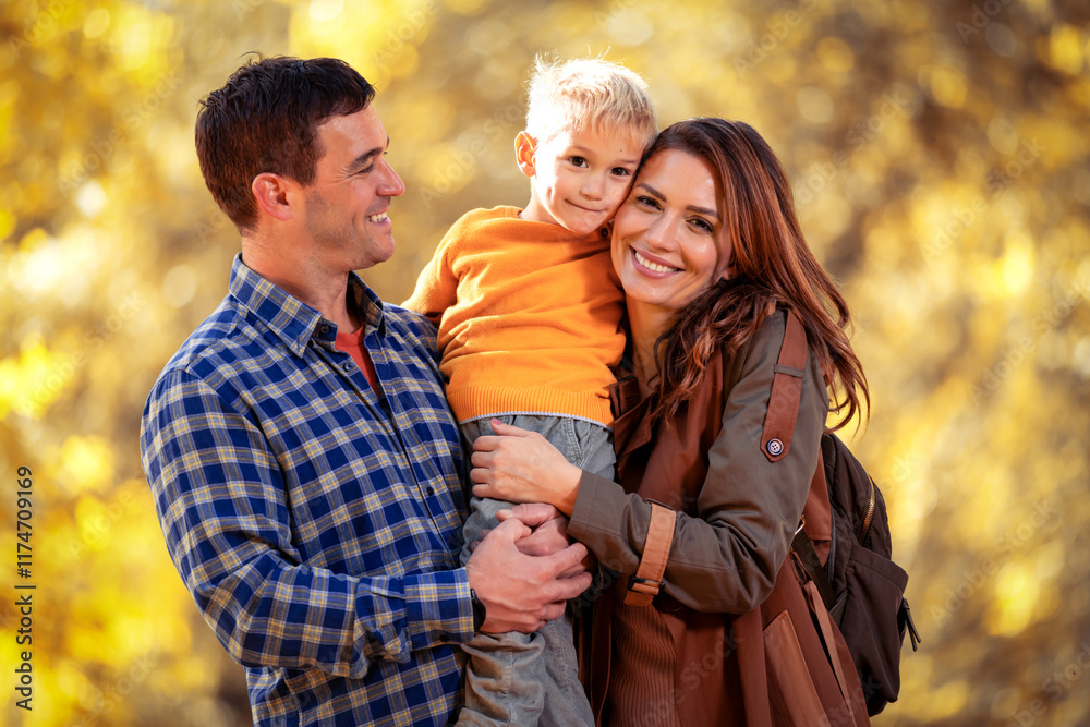 Fototapeta premium Happy family with one child walking in beautiful autumn park