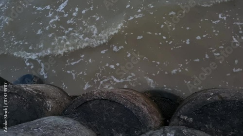 Ocean waves hit concrete breakwater. Wave breakers to reduce coastal erosion due to wave erosion. Wave breaker on the beach at Pamekasan, indonesia photo