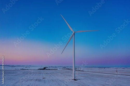 Snowy landscape with a wind turbine at dawn. Renewable energy source in a rural setting. , Fort Macleod, Alberta, USA photo