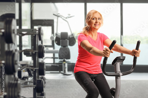 Mature woman in sportswear exercising on a stationary bike