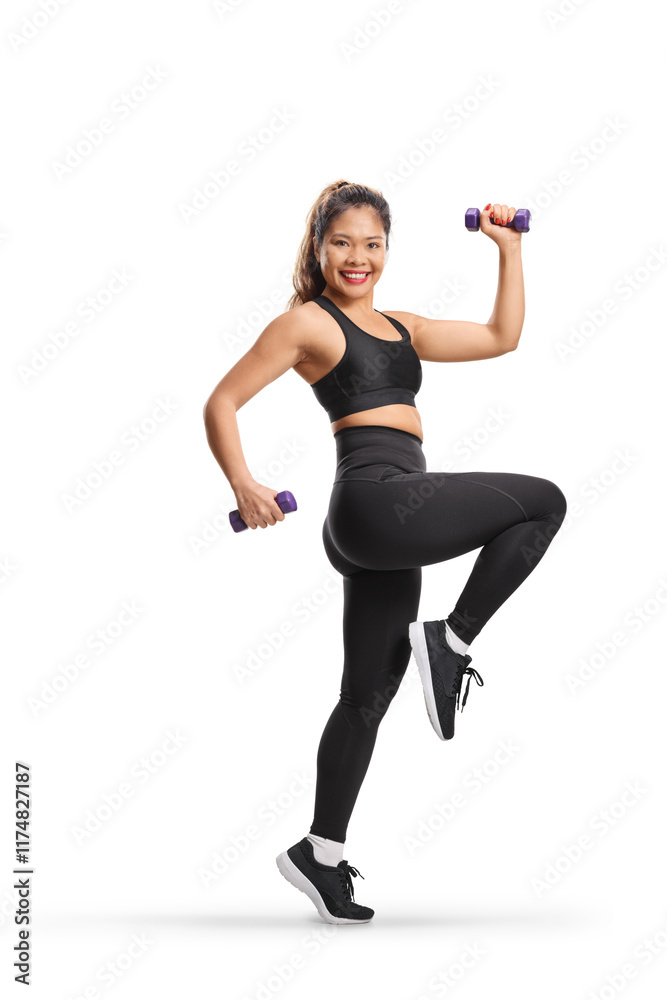 Cheerful young asian woman exercising with weights