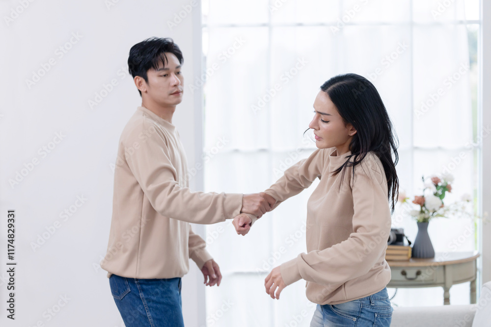 Angry man grabbing his scared partner hand while they have a fight Angry man grabbing his scared partner hand while they have a fight
