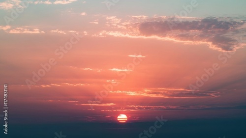 Beautiful sunset sky with scattered light clouds in shades of orange, pink, and blue over the horizon