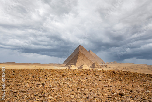 Egypt. Cairo - Giza. General view of pyramids from the Giza Plateau against the background of a gloomy stormy sky. (three pyramids known as Queens' Pyramids on front side; next in order from left: the