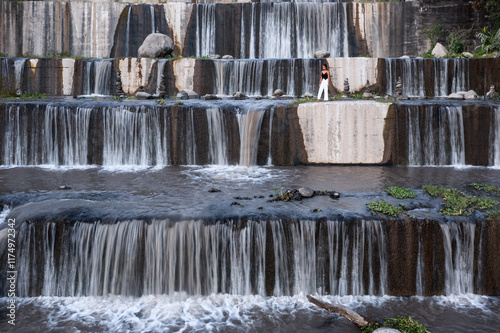 Woman standing on artificial waterfall, Yogyakarta, Java, Indonesia