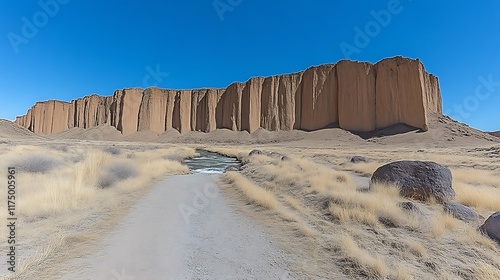 Desert Landscape Featuring Imposing Sandstone Cliffs and Stream photo