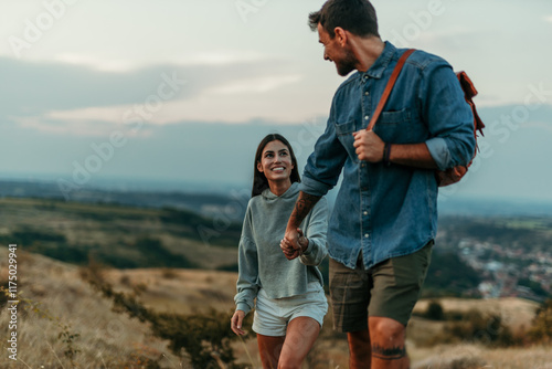 A smiling couple walking and enjoying a quiet moment together in a vast meadow at dusk. Travel and lifestyle concept