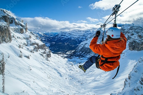 Person ziplines over snowy mountain vista.
