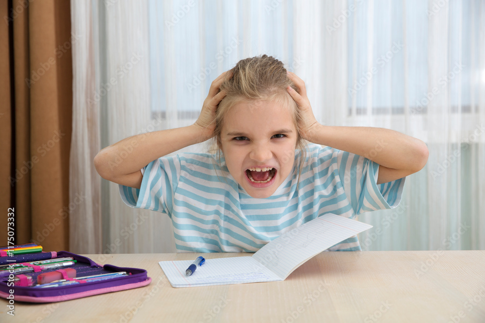 sad tired girl of eight holds her head in her hands and screams does homework sitting at the table at home sad tired girl of eight holds her head in her hands and screams does homework sitting at the table at home