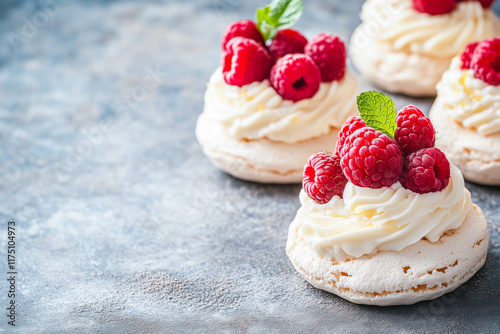 Delicious raspberry mini pavlovas with whipped cream and mint garnish on rustic surface photo