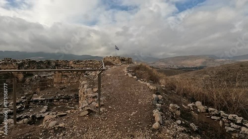 Ruins of the ancient fortress at Tel Hazor, a UNESCO World Heritage Site in northern Israel's Galilee, set against dramatic cloudy skies.