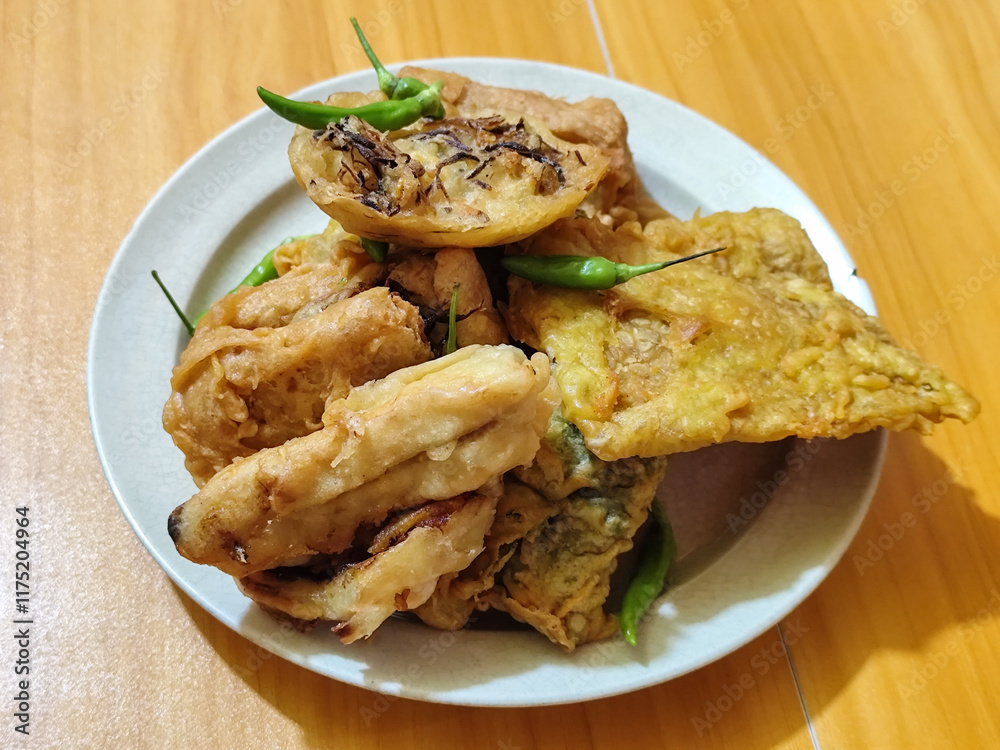 Gorengan, a traditional Indonesian street food consisting of tahu brontak, fried banana, bakwan, tempe mendoan, etc. Served with green chili. Gorengan, a traditional Indonesian street food consisting of tahu brontak, fried banana, bakwan, tempe mendoan, etc. Served with green chili.