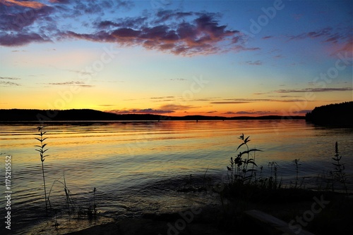 Colorful sunset on a lake in Finland in summer. Reflections on the surface of the lake