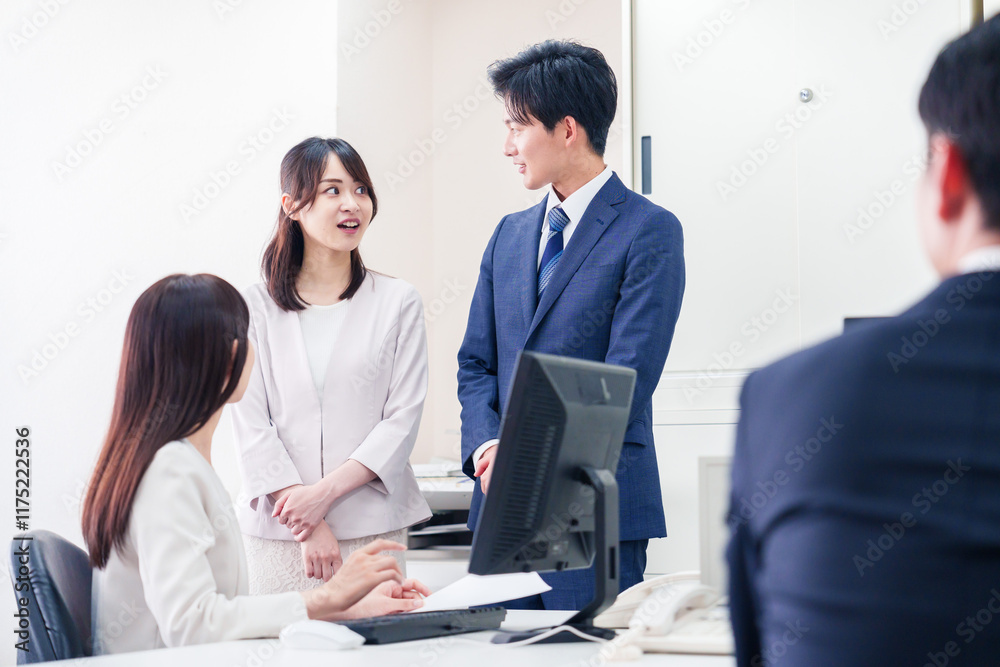 職場で上司に結婚の報告をするビジネスパーソンのカップル 職場で上司に結婚の報告をするビジネスパーソンのカップル