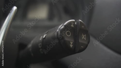 Wipers switch control on steering wheel. Car radio lever switch control paddle on steering wheel. Adjusting speed of screen wipers in car