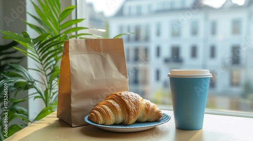 Croissant, paper cup of coffee and paper bag on a table, cityview on background