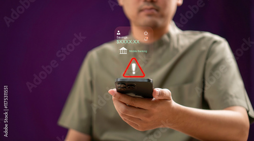 Obraz na płótnie A man holding a smartphone with a alert sign indicating a warning related to mobile banking. online banking risks, cybersecurity issues, and financial technology awareness. w salonie