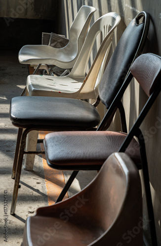 Obraz na płótnie Perspective side view of Different of Chairs with Morning sunlight shines through with concrete wall in the background. use it as your Wallpaper, Poster and Copy space, Selective focus. w salonie