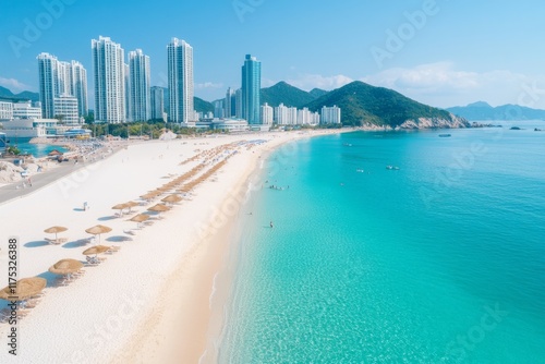 A scenic shot of Haeundae Beach in Busan, with modern high-rises in the distance and parasols lining the sandy shore