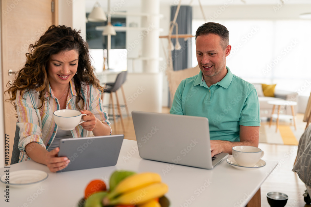Caucasian couple in casual attire using digital devices while enjoying coffee at home. Professional setting with modern furniture and fresh fruit. Caucasian couple in casual attire using digital devices while enjoying coffee at home. Professional setting with modern furniture and fresh fruit.