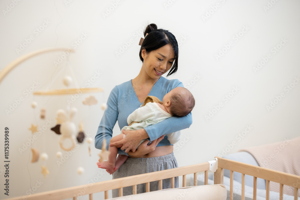 Asian mother holding her baby at home