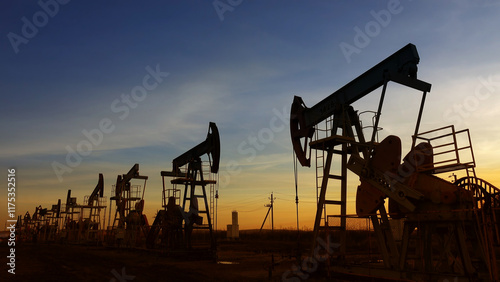 working oil pumps silhouette against sunset photo