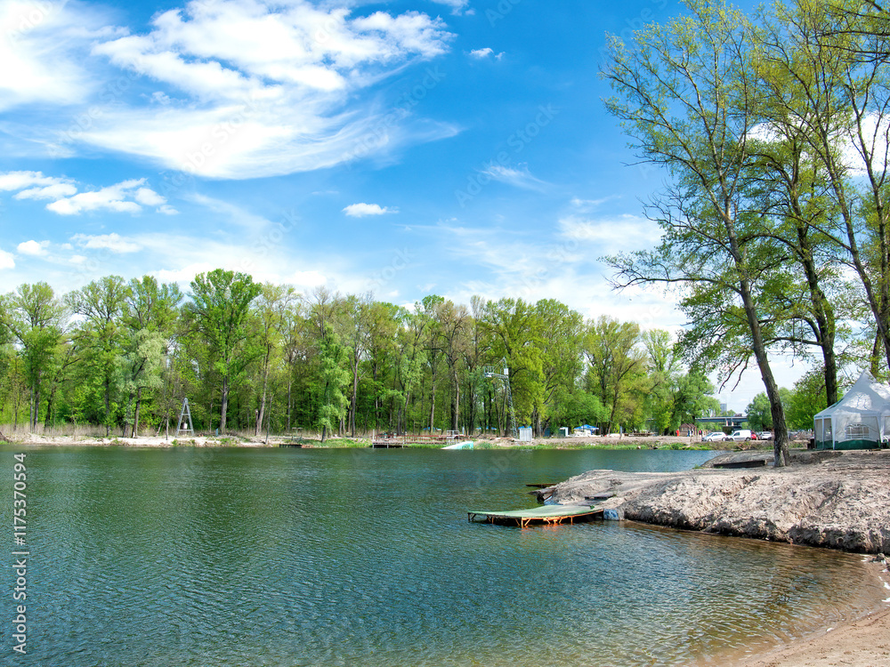 Tranquil lakeside retreat with clear skies and lush green scenery
