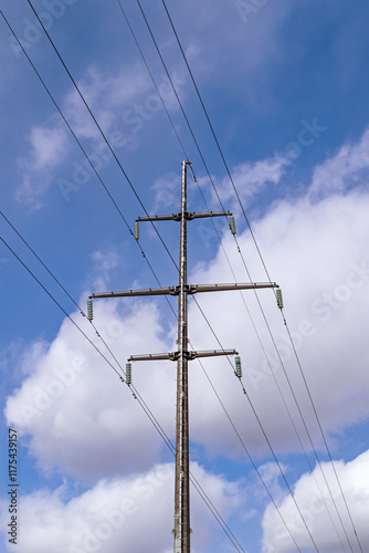 support for a high-voltage power line against the blue sky and sunlight. close up photo